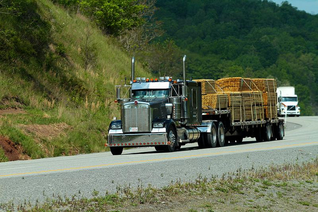 A semi truck hauling a bunch of lumber.