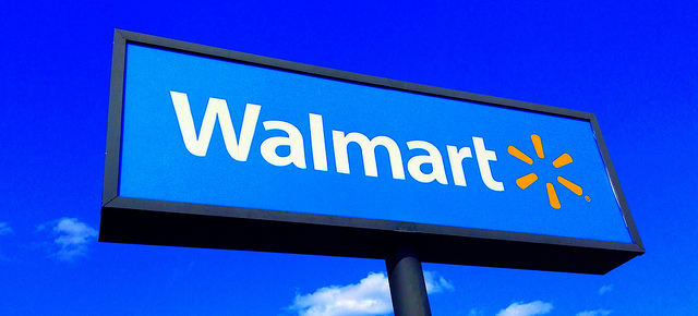 A tall Walmart sign against a clear, blue sky.